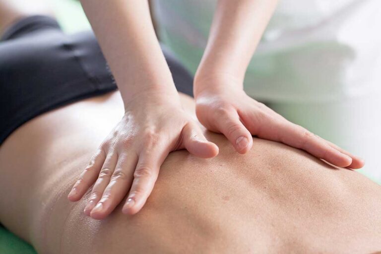 Parent discusses a child’s back discomfort with a clinician in a bright examination room.
